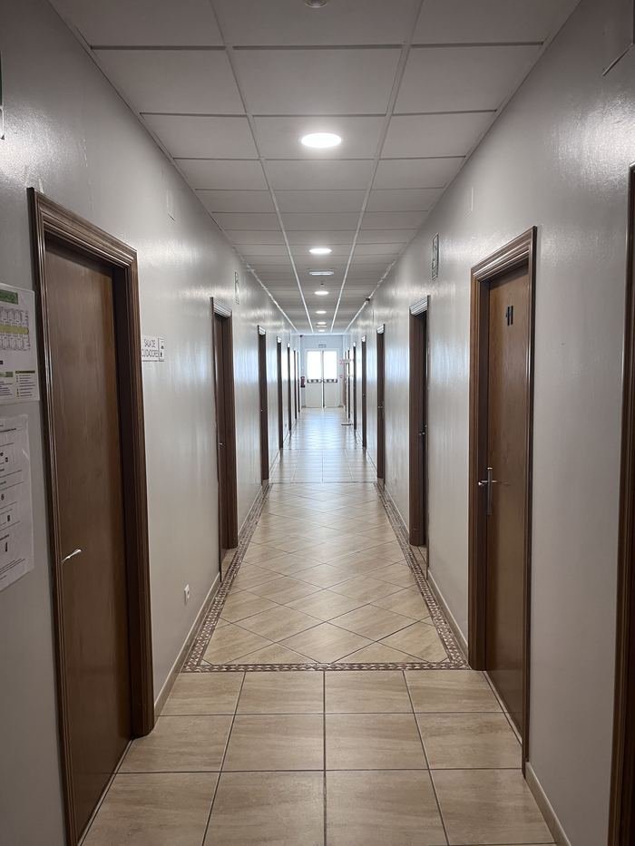 Pasillo de la residencia con puertas de madera a ambos lados