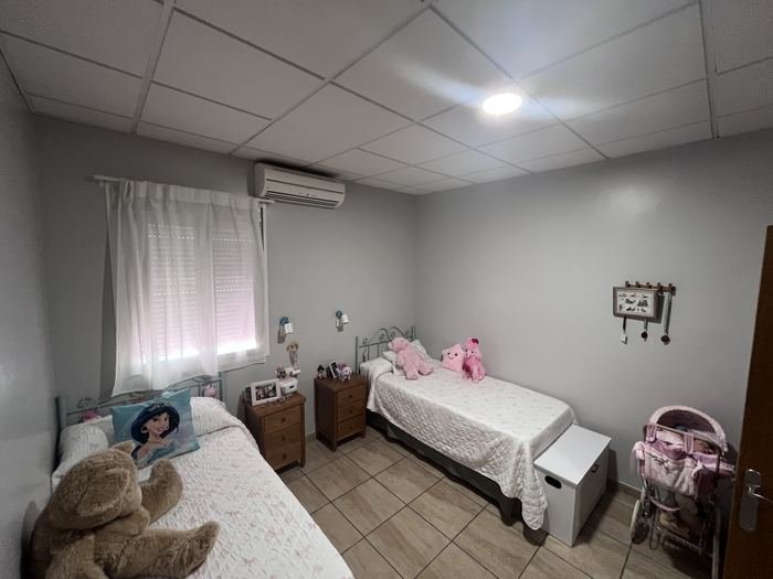 Habitación de la residencia con dos camas, mesillas y ventana